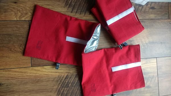 Rote Wetbags die auf einer hölzernen Unterlagen drapiert wurden